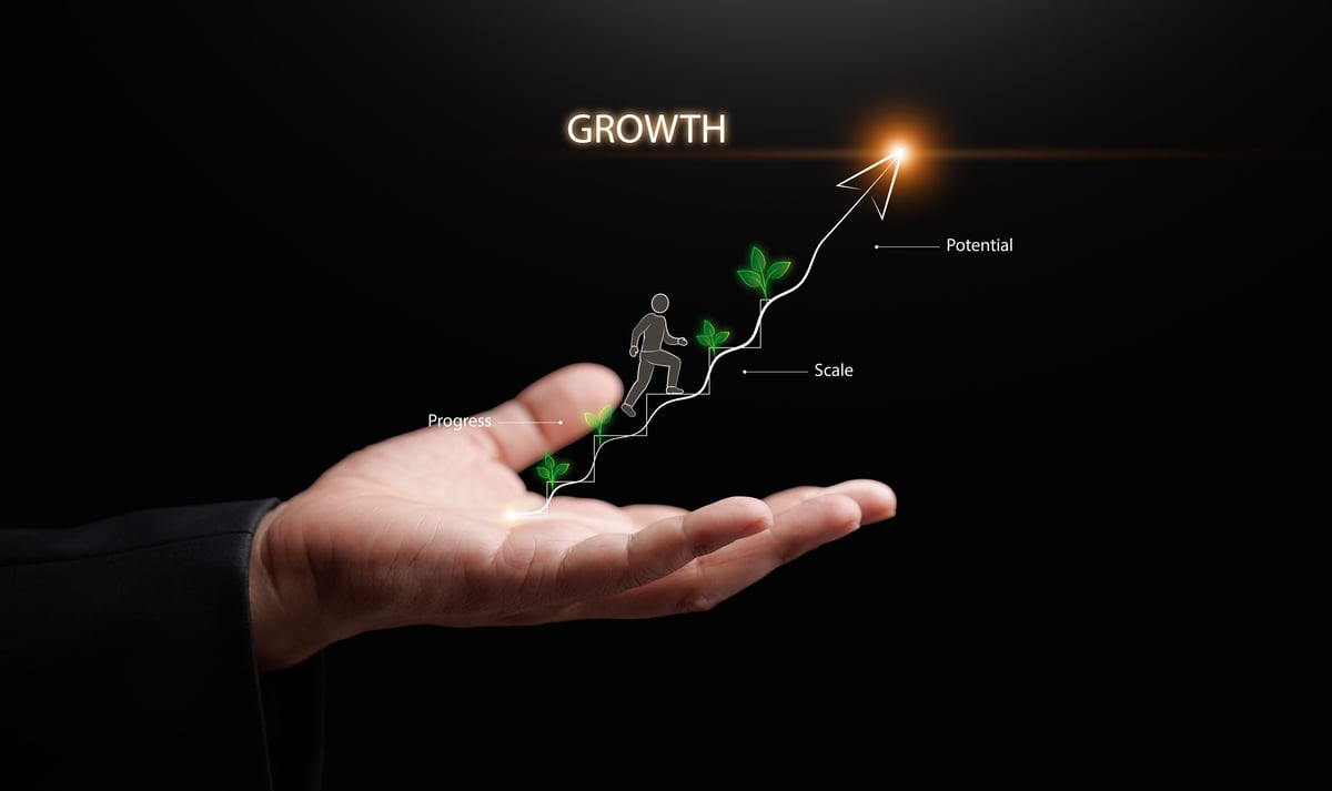 Business hand holding a growth arrow with a small plant